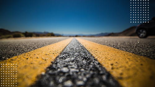 yellow lines on long road with view of sky