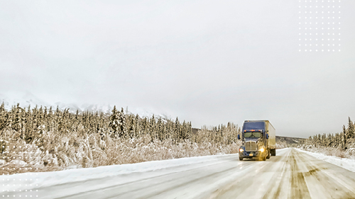 truck driving in the winter weather on a road with snow